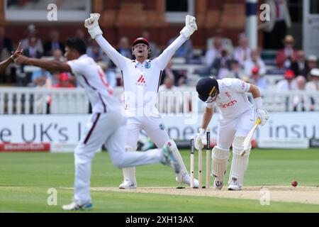 Joe Root (a destra) dell'Inghilterra reagisce dopo essere stato bocciato da Gudakesh Motie (a sinistra) delle Indie occidentali il secondo giorno del primo Rothesay Men's test match al Lord's Cricket Ground di Londra. Data foto: Giovedì 11 luglio 2024. Foto Stock