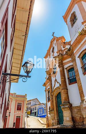 chiesa barocca del 18th secolo vista dal basso con le case di stile coloniale circostante e pendio di ciottoli sullo sfondo nella città storica di Foto Stock