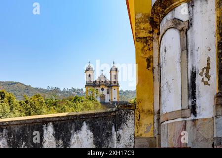 Due delle molte chiese storiche in stile barocco e coloniale del 18 ° secolo nella città di Ouro Preto a Minas Gerais, Brasile in prospettiva Foto Stock