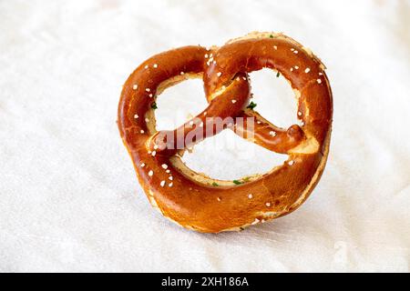 Pretzel bavarese con burro su bianco Foto Stock