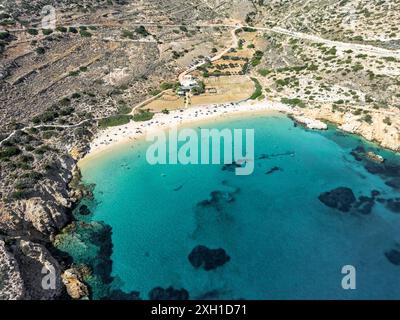 Spiaggia di Kedros a Donousa: Mezzaluna isolata di sabbia tra le scogliere. Le acque turchesi risplendono alla luce del sole, invitando al relax Foto Stock