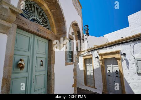 Vecchio edificio bianco con archi e porte ornati in un ambiente mediterraneo soleggiato, Chora, città vecchia, Patmos, Dodecaneso, isole greche, Grecia Foto Stock