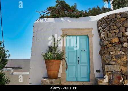 Porta di colore turchese in un edificio bianco con piante e mura in vaso, Chora, città vecchia, Patmos, Dodecaneso, isole greche, Grecia Foto Stock