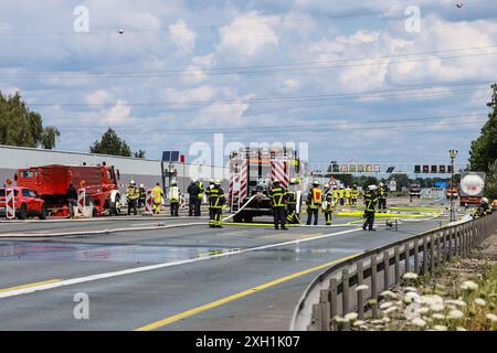 Unna, Germania. 11 luglio 2024. I vigili del fuoco si trovano sull'autostrada A1 tra lo svincolo di Kamener Kreuz e Dortmund/Unna vicino a un camion di merci pericolose (r) che stava perdendo gas. L'autostrada doveva essere chiusa in entrambe le direzioni a causa della perdita del serbatoio del carrello. Credito: Alex Talash/dpa - ATTENZIONE: Il nome dell'azienda e la targa del carrello cisterna sono stati appiattiti per motivi legali/dpa/Alamy Live News Foto Stock