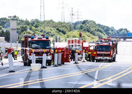 Unna, Germania. 11 luglio 2024. I vigili del fuoco si trovano sull'autostrada A1 tra lo svincolo di Kamener Kreuz e Dortmund/Unna vicino a un camion di merci pericolose (non illustrato) che stava perdendo gas. L'autostrada doveva essere chiusa in entrambe le direzioni a causa della perdita del serbatoio del carrello. Credito: Alex Talash/dpa/Alamy Live News Foto Stock