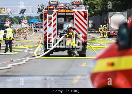 Unna, Germania. 11 luglio 2024. I vigili del fuoco si trovano sull'autostrada A1 tra lo svincolo di Kamener Kreuz e Dortmund/Unna vicino a un camion merci pericolose (r) che stava perdendo gas. L'autostrada doveva essere chiusa in entrambe le direzioni a causa della perdita del serbatoio del carrello. Credito: Alex Talash/dpa - ATTENZIONE: Il nome dell'azienda e la targa del carrello cisterna sono stati appiattiti per motivi legali/dpa/Alamy Live News Foto Stock