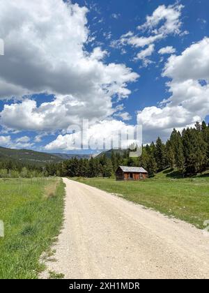 Una capanna rustica in legno in un paesaggio di foresta e montagna. Big Snowy Mountains, Montana Foto Stock