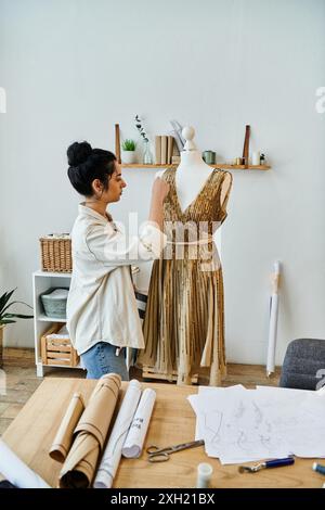 Giovane donna che upcycling vestiti, che lavora su un vestito da manichino. Foto Stock