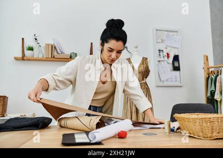 Una giovane donna con un abbigliamento casual che indossa i suoi vestiti, lavorando a un progetto. Foto Stock