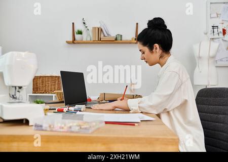 Una giovane donna ricicla abiti, rispetta l'ambiente, lavora con un notebook. Foto Stock