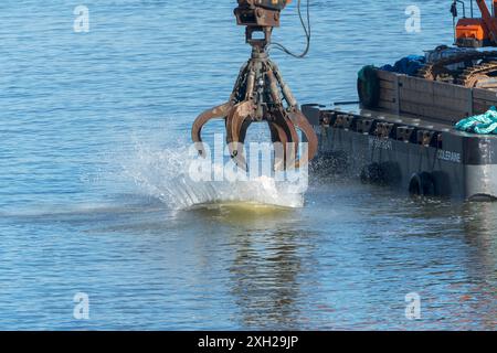 Lavori di protezione contro l’erosione costiera con macchinari provenienti da una chiatta in mare, Cromer, Norfolk, Inghilterra, Regno Unito, Europa Foto Stock