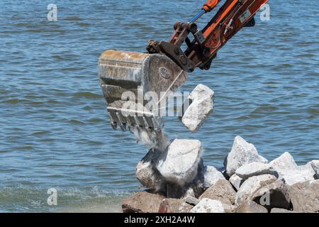 Lavori di protezione contro l’erosione costiera con macchinari provenienti da una chiatta in mare, Cromer, Norfolk, Inghilterra, Regno Unito, Europa Foto Stock