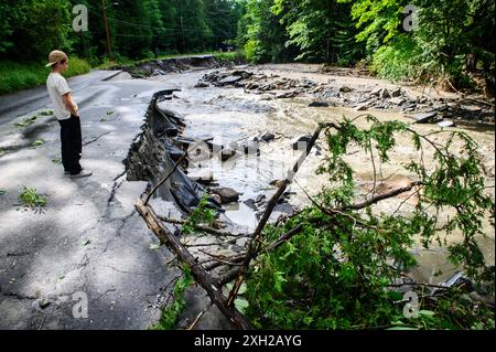 Plainfield, Vermont, Stati Uniti. 11 luglio 2024. Un ragazzo in piedi sui resti di Brook Road guarda Great Brook dopo le piogge torrenziali dei resti dell'uragano Beryl che ha colpito il Vermont centrale, Stati Uniti. John Lazenby/Alamy Live News Foto Stock