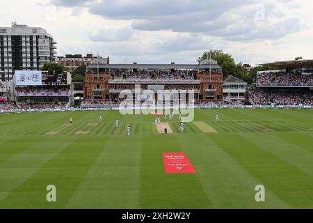 L'inglese Ben Stokes (a sinistra) festeggia con i compagni di squadra dopo aver preso il wicket di Kirk McKenzie delle Indie occidentali (non nella foto), che ha segnato il suo 200 ° wicket, il secondo giorno del primo Rothesay Men's test match al Lord's Cricket Ground, Londra. Data foto: Giovedì 11 luglio 2024. Foto Stock