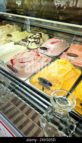 Una vetrina piena di vari gusti di gelato in una gelateria italiana Foto Stock