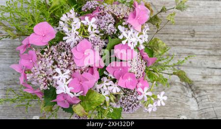 Bouquet estivo con ortensie rosa, erba saponata e origano Foto Stock