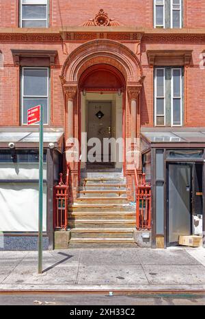 NYC Chinatown: L'elaborata terracotta e le colonne danno il benvenuto al numero 1 di Elizabeth Street; la fredda porta in acciaio grigio dice di stare lontano. Foto Stock