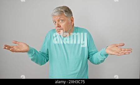 Un uomo anziano confuso che si scaglia su uno sfondo bianco, illustrando incertezza o dubbio. Foto Stock