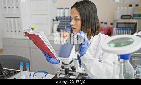 Una giovane scienziata concentrata che esamina un campione in laboratorio, dimostrando professionalità e determinazione. Foto Stock