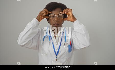 Donna nera di mezza età, medico con capelli ricci che soffrono di mal di testa, chiudono gli occhi e toccano le tempie, isolata su sfondo bianco Foto Stock