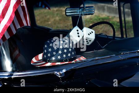 Un paio di "dadi fuzzy" pendono dal mirino posteriore di un'auto d'epoca che partecipa a una parata del 4 luglio a Hendersonville, North Carolina. Foto Stock