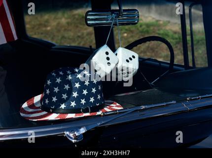 Un paio di "dadi fuzzy" pendono dal mirino posteriore di un'auto d'epoca che partecipa a una parata del 4 luglio a Hendersonville, North Carolina. Foto Stock