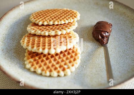 Arrotondare i waffle e la crema di cioccolato su un piatto con sfondo bianco Foto Stock