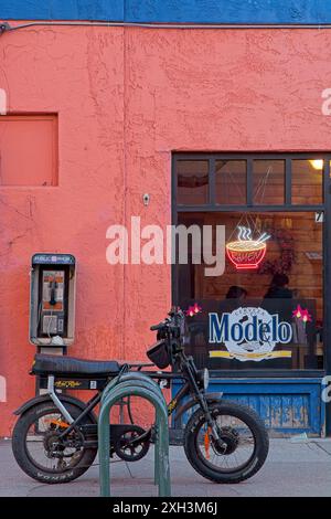 Bici elettrica parcheggiata di fronte al negozio di noodle Raman nel centro di Flagstaff, Arizona - aprile 2024 Foto Stock