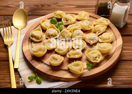 Bordo con gnocchi crudi e basilico su fondo in legno Foto Stock