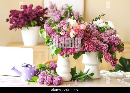 Vasi con bellissimi fiori sul tavolo nel fioraio studio Foto Stock