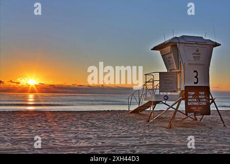Il sole sorge sull'oceano atlantico illuminando un bagnino in Florida Foto Stock