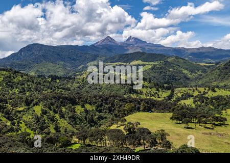 Paesaggio andino che combina campi coltivati, foreste umide, montagne e cielo blu Foto Stock