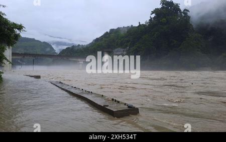 Teesta Bazar, Bengala Occidentale, INDIA. 12 luglio 2024. Le acque del fiume Teesta scorrono sulle strade adiacenti al fiume Teesta, dove l'acqua entra nelle strade vicine alle loro case a causa del livello dell'acqua salito del fiume, che scorre accanto alla National Highway 10, collegando il vicino stato del Sikkim al Bengala Occidentale nad anche Darejeeling, Kalimpong nell'area di Teesta Bazar nel Bengala Occidentale. (Credit Image: © Diptendu Dutta/ZUMA Press Wire) SOLO PER USO EDITORIALE! Non per USO commerciale! Foto Stock