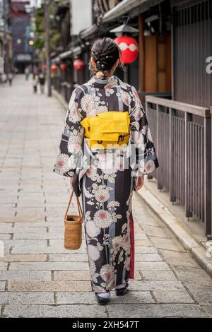 Una donna in un kimono cammina lungo una strada. Kyoto, Giappone. Foto Stock