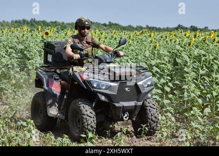 Un soldato ucraino della squadra di evacuazione della 65a brigata meccanizzata separata guida un ATV di evacuazione (veicolo fuoristrada) vicino a Orikhiv. I difensori ucraini utilizzano passeggini da spiaggia, quad (fuoristrada) e biciclette elettriche davanti perché questi veicoli sono più silenziosi e difficili da vedere e sentire. Questo dà ai soldati in prima linea una migliore possibilità di evitare i droni russi e sopravvivere. Questi piccoli veicoli non sostituivano i tradizionali veicoli militari. Non hanno la potenza di fuoco e lo spazio per trasportare un gran numero di persone o merci, e la loro mancanza di armatura lascia tutti su bo Foto Stock