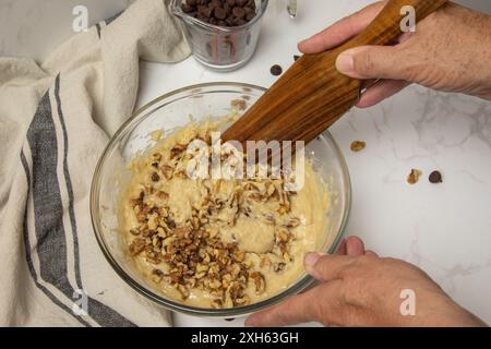 Stirring walnuts into the muffin batter Stock Photo