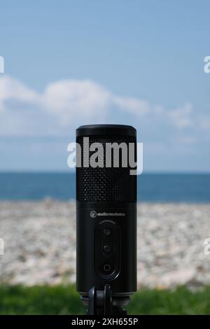 microfono su una spiaggia di ciottoli contro il cielo Foto Stock