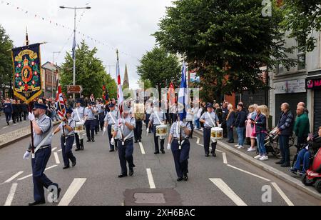 Lurgan, Contea di Armagh, Irlanda del Nord.12 luglio 2024. Il dodicesimo luglio è caratterizzato da sfilate dell'ordine arancione in tutta l'Irlanda del Nord. Il distretto di Lurgan ha lasciato il quartier generale a Brownlow House prima di raggiungere il memoriale di guerra in vista della principale manifestazione della contea di Armagh che si terrà quest'anno a Killylea. Le parate in tutta l'Irlanda del Nord segnano la vittoria di Guglielmo d'Orange su Giacomo nella battaglia del Boyne nel 1690. Crediti: CAZIMB/Alamy Live News. Foto Stock