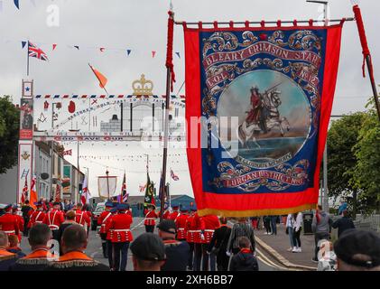 Lurgan, Contea di Armagh, Irlanda del Nord.12 luglio 2024. Il dodicesimo luglio è caratterizzato da sfilate dell'ordine arancione in tutta l'Irlanda del Nord. Il distretto di Lurgan ha lasciato il quartier generale a Brownlow House prima di raggiungere il memoriale di guerra in vista della principale manifestazione della contea di Armagh che si terrà quest'anno a Killylea. Le parate in tutta l'Irlanda del Nord segnano la vittoria di Guglielmo d'Orange su Giacomo nella battaglia del Boyne nel 1690. Crediti: CAZIMB/Alamy Live News. Foto Stock
