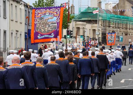 Lurgan, Contea di Armagh, Irlanda del Nord.12 luglio 2024. Il dodicesimo luglio è caratterizzato da sfilate dell'ordine arancione in tutta l'Irlanda del Nord. Il distretto di Lurgan ha lasciato il quartier generale a Brownlow House prima di raggiungere il memoriale di guerra in vista della principale manifestazione della contea di Armagh che si terrà quest'anno a Killylea. Le parate in tutta l'Irlanda del Nord segnano la vittoria di Guglielmo d'Orange su Giacomo nella battaglia del Boyne nel 1690. Crediti: CAZIMB/Alamy Live News. Foto Stock