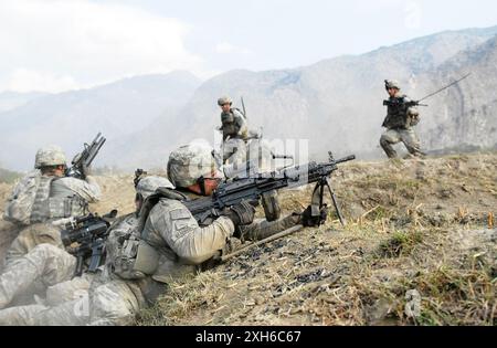 GUERRA IN AFGHANISTAN soldati dell'esercito americano della compagnia C, 2nd Battalion, 12th Infantry Regiment, osservano le colline circostanti per gli insorti, mentre compagni Co.. I soldati C corrono verso la loro posizione, schivando pesanti colpi di cecchino, durante una battaglia di tre ore con le forze insorti nella provincia di Kunar, nella valle di Waterpur, in Afghanistan, il 3 novembre. I soldati della 4th Infantry Division hanno combattuto le forze ribelli nella valle di Waterpur da quando sono arrivati in Afghanistan lo scorso giugno. 5th Mobile Public Affairs Detachment foto di Sgt. Matthew Moeller Data: 11.03.2009 luogo: Provincia di Kunar. Foto Stock