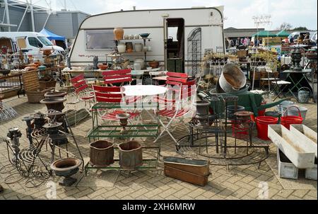 Banchina all'aperto per la fiera dell'antiquariato con pentole e caravan di mobili da giardino sullo sfondo. Foto Stock