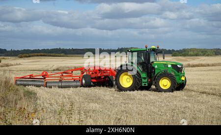 Trattore sul campo con impacchettamento del terreno King Roller nelle giornate di sole Foto Stock