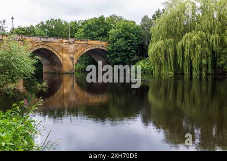 Una vista panoramica del fiume Tees a Yarm, Inghilterra, Regno Unito, che mostra il ponte stradale e le rive alberate del fiume con riflessi sull'acqua Foto Stock