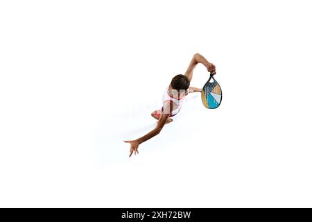 Tiro aereo di atleta maschile, giocatore di Beach tennis con canotta e pantaloncini corti, palla con pagaia multicolore isolata su sfondo bianco Foto Stock