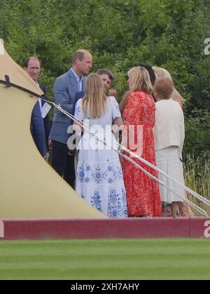 Il principe di Galles parla agli ospiti al di fuori della tenda dell'ospitalità dell'associazione di polo degli Stati Uniti durante la Out-Sourcing Inc Royal Charity Polo Cup 2023 presso il Guards Polo Club di Windsor, Berkshire. Data foto: Venerdì 12 luglio 2024. Foto Stock