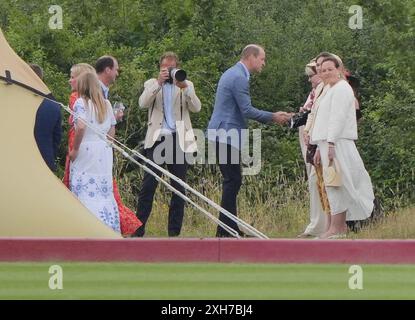 Il principe di Galles parla agli ospiti al di fuori della tenda dell'ospitalità dell'associazione di polo degli Stati Uniti durante la Out-Sourcing Inc Royal Charity Polo Cup 2023 presso il Guards Polo Club di Windsor, Berkshire. Data foto: Venerdì 12 luglio 2024. Foto Stock