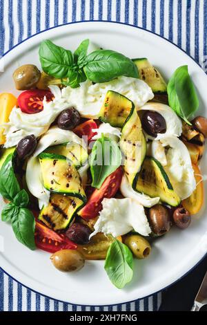 Insalata mediterranea con mozzarella, olive, basilico e verdure alla griglia Foto Stock