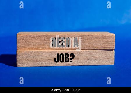 È necessario scrivere un messaggio di domanda di lavoro su blocchi di legno con sfondo blu. Il concetto ha bisogno di un simbolo di lavoro. Copia spazio. Foto Stock