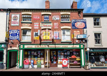 Cartelli pubblicitari in smalto vintage sulla facciata del negozio indipendente Gwalia, Ross on Wye, Herefordshire, Inghilterra Foto Stock